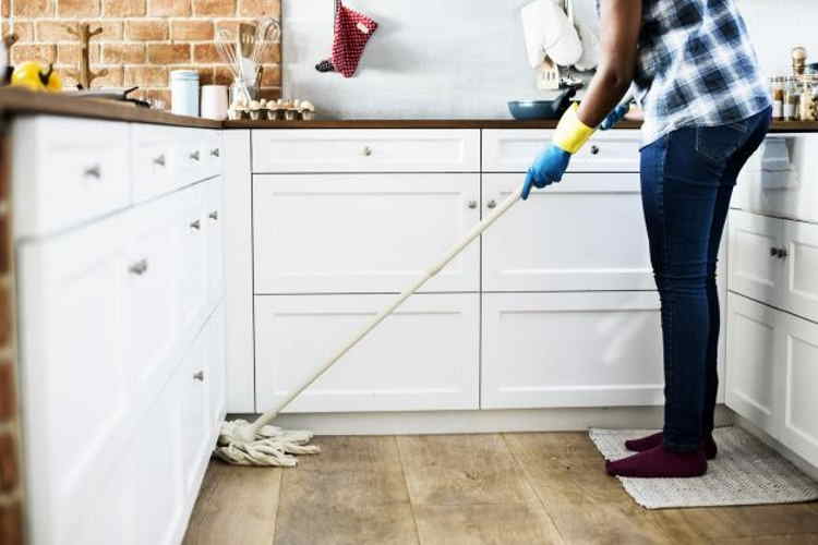 Woman mopping floor with everyday cleaning product that could harm your dog