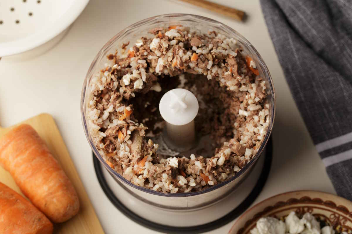 Combining homemade dog food ingredients Using a food processor to mix homemade dog food